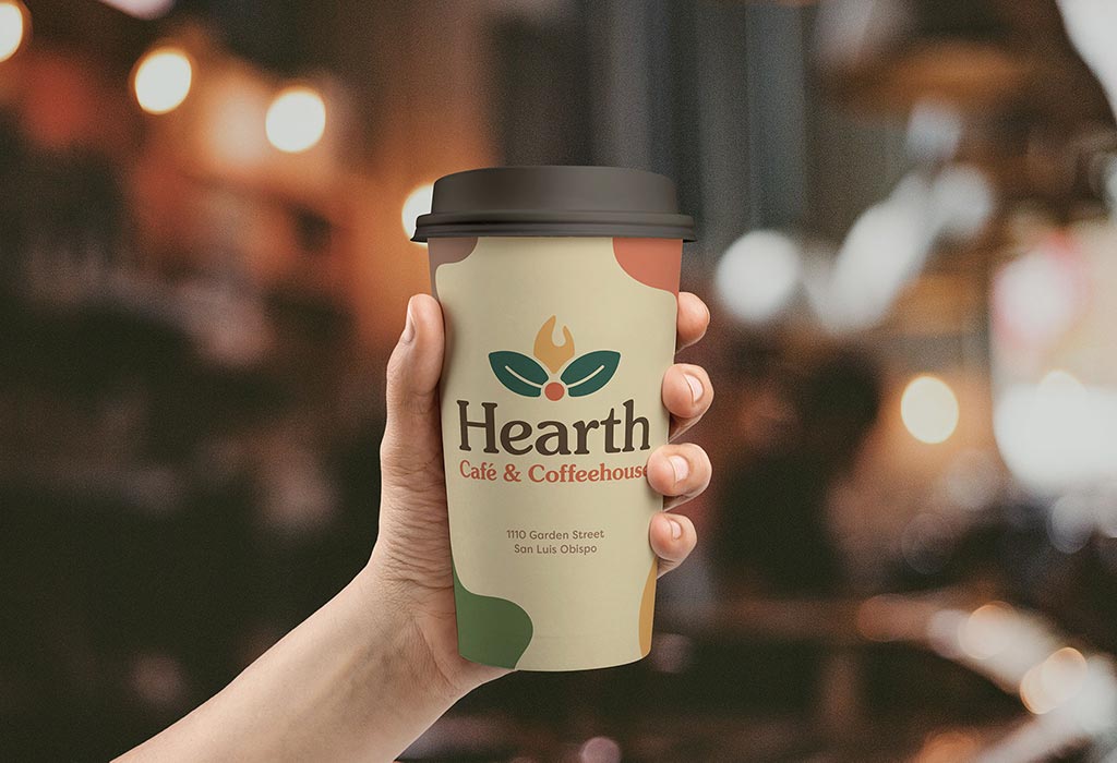 Hand holding a to-go coffee cup displaying the new Hearth branding